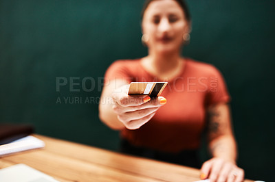 Buy stock photo Cropped shot of an unrecognizable businesswoman sitting alone and holding out her credit card