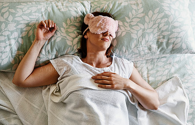 Buy stock photo Shot of an attractive young woman sleeping with a sleep mask on in her bed at home