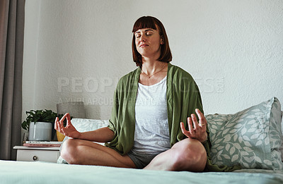 Buy stock photo Full length shot of an attractive young woman meditating while sitting on her bed at home