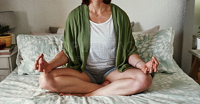 Buy stock photo Cropped shot of an unrecognizable young woman meditating while sitting on her bed at home