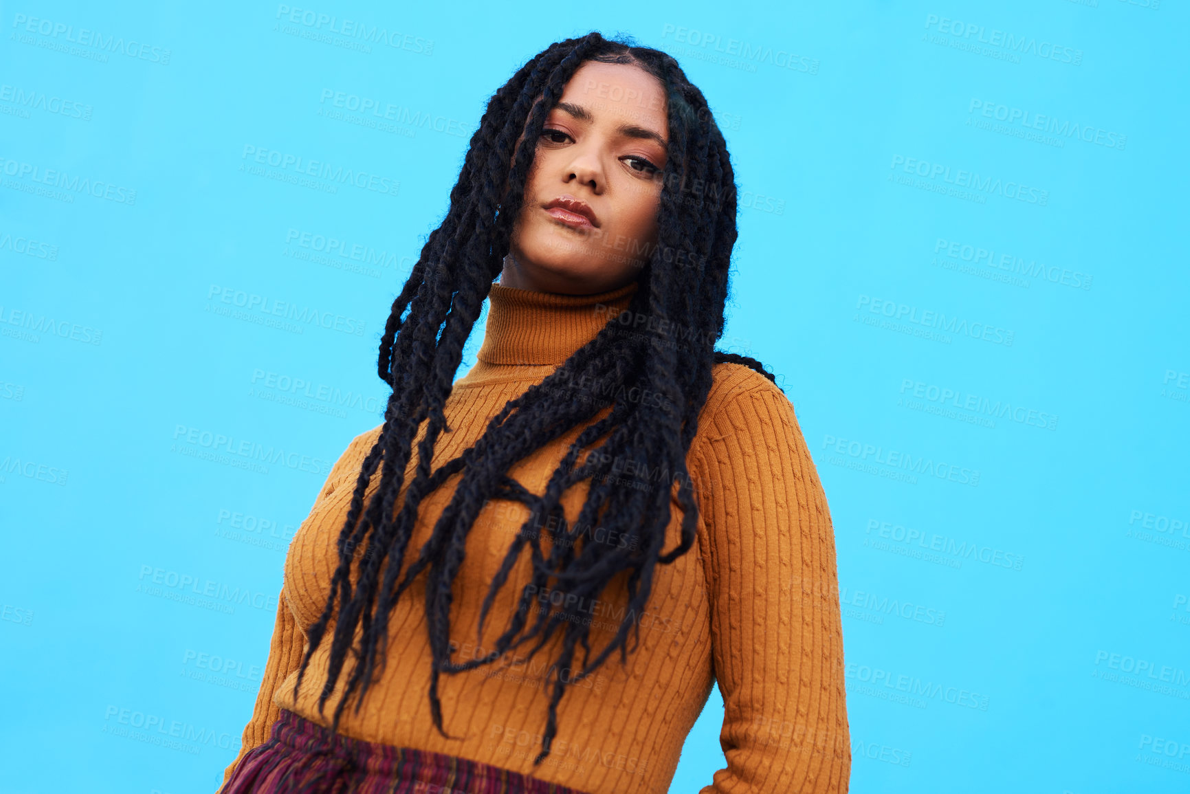 Buy stock photo Cropped shot of a beautiful young woman posing against a blue wall