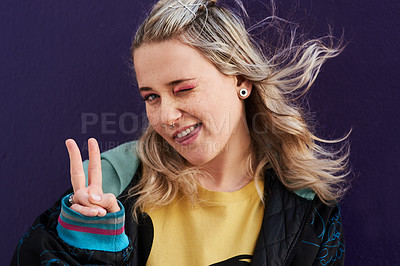 Buy stock photo Portrait, woman tongue and peace sign with wink for y2k fashion and silly by dark background. Gen z girl, happy smile and v emoji for hand with street style confidence and comedy face for piercing