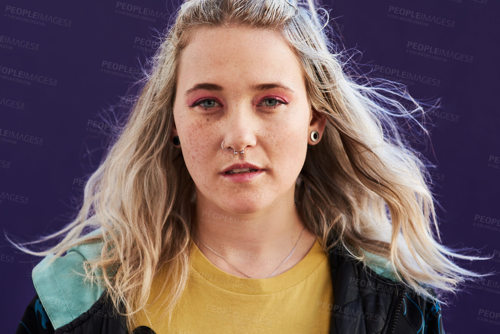 Buy stock photo Cropped shot of a beautiful young woman posing against a purple background