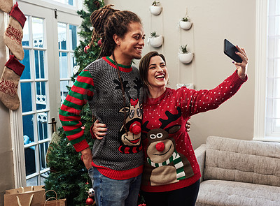Buy stock photo Cropped shot of a cheerful young couple taking a self portrait together at home during christmas time