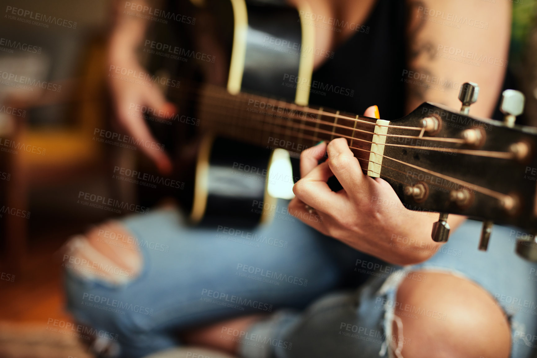Buy stock photo Cropped shot of an unrecognizable woman playing a guitar at home