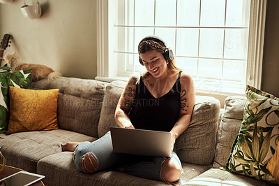 Buy stock photo Computer, headphones and woman on sofa and music, happy work from home for mental health in apartment. Young person relax on couch and listening to audio technology, electronics and working on laptop
