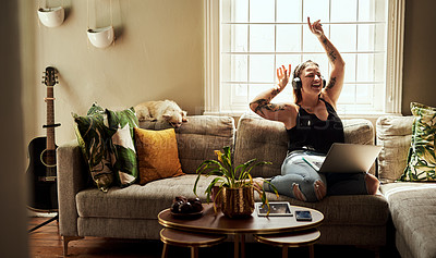 Buy stock photo Woman, dancing and headphones on couch and laptop, happy energy or mental health with music at home. Young gen z person on sofa singing, dance and listening to audio tech on computer in living room