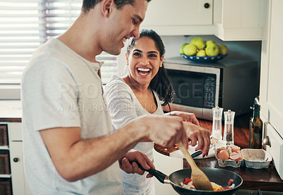 Buy stock photo Cropped shot of a happy young couple preparing breakfast together