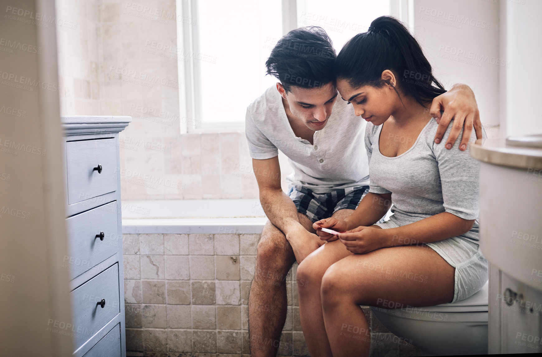 Buy stock photo Shot of a young couple waiting for the result of a home pregnancy test