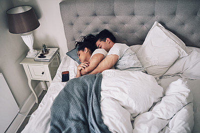 Buy stock photo Shot of a young couple sleeping together in their bed