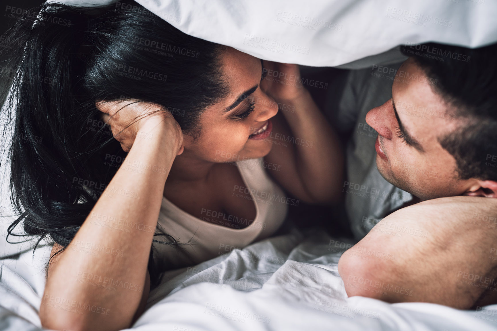 Buy stock photo Cropped shot of an affectionate couple lying in bed