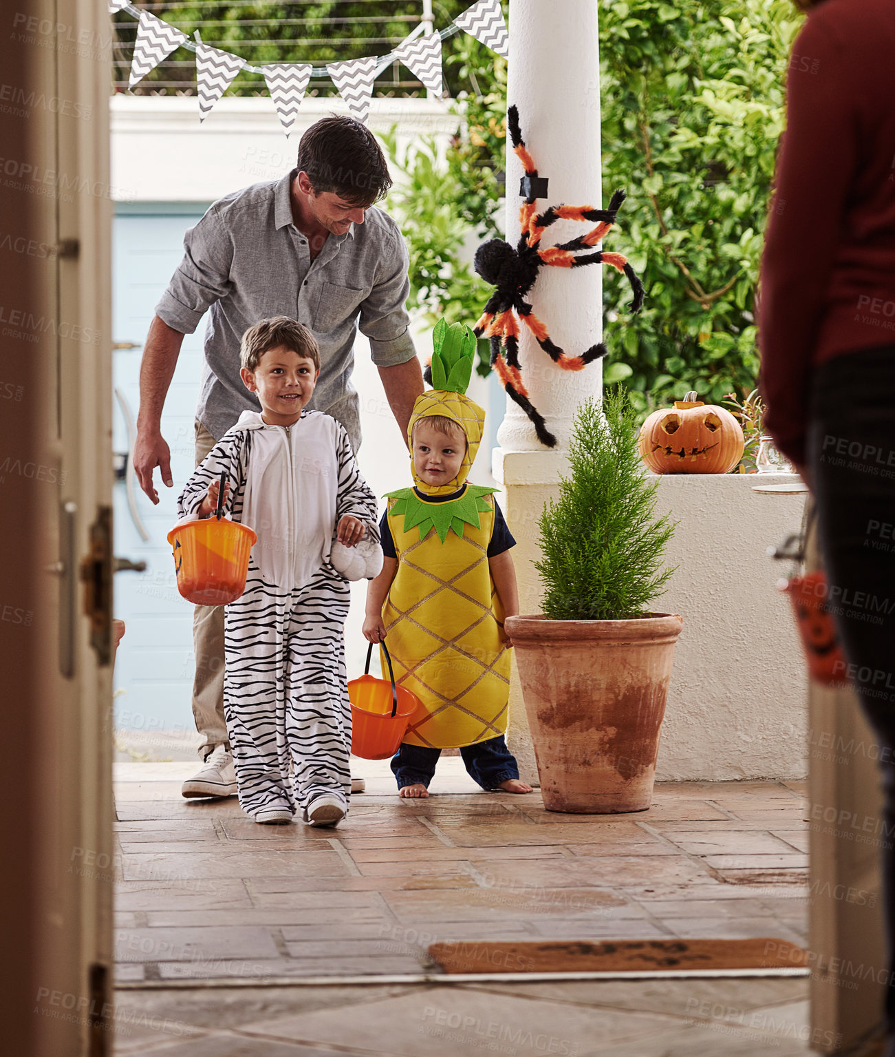 Buy stock photo Full length shot of a father and his adorable young sons trick or treating together on halloween