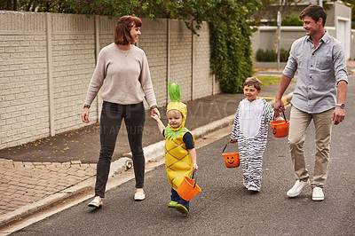 Buy stock photo Full length shot of an adorable young family trick or treating together in the neighborhood on halloween