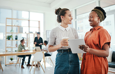 Buy stock photo Cropped shot of two attractive young businesswomen standing together and having a discussion in the office