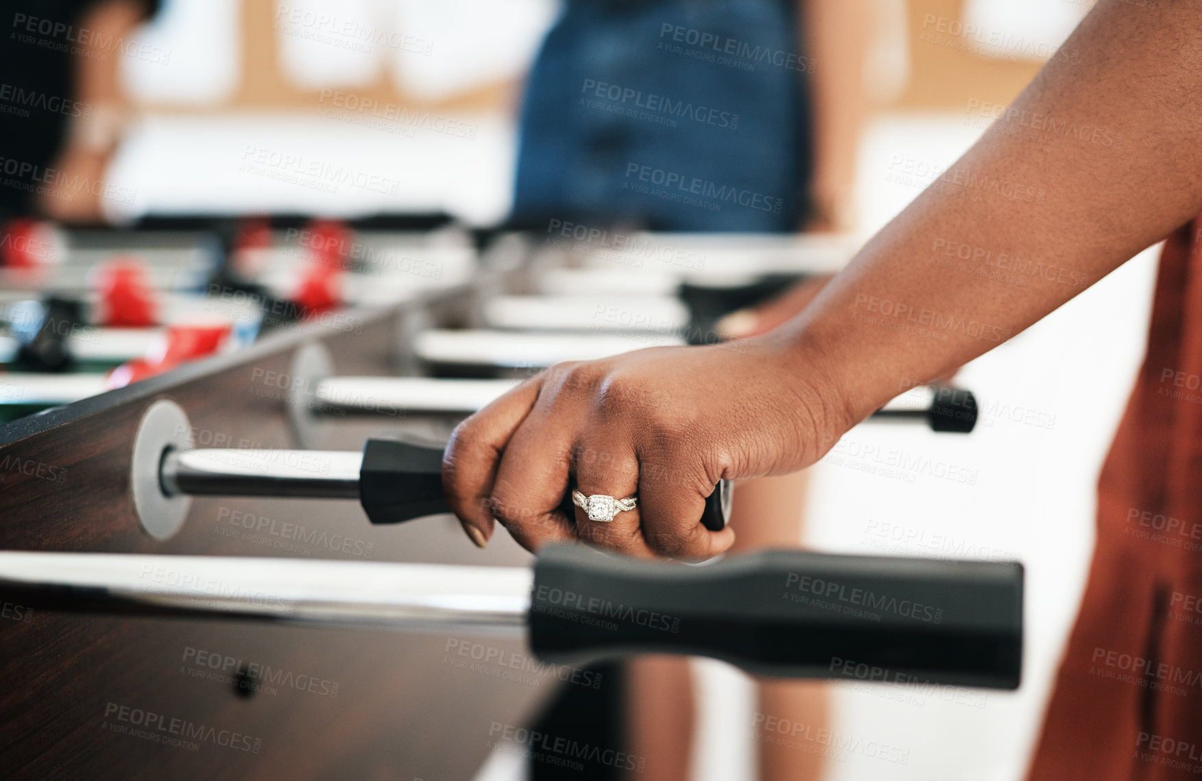Buy stock photo Cropped shot of an unrecognizable businesswoman wearing a ring and ready to play a game of foosball