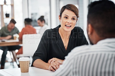 Buy stock photo Cropped shot of an attractive young businesswoman sitting and having a discussion with a colleague in the office