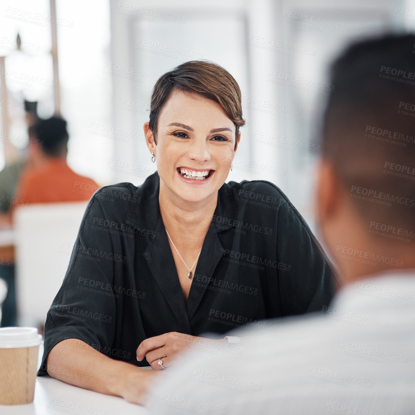Buy stock photo Cropped shot of an attractive young businesswoman sitting and having a discussion with a colleague in the office