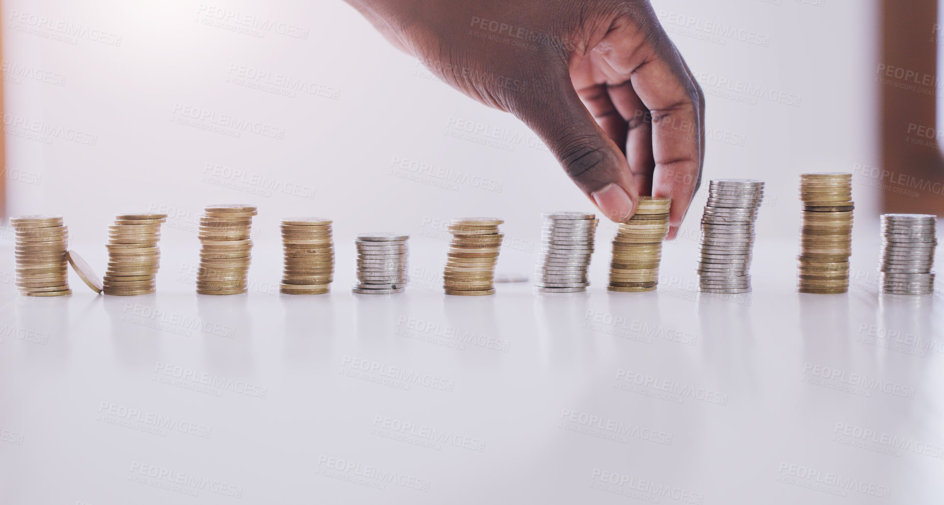 Buy stock photo Cropped shot of an unrecognizable businessman stacking up coins in his office during the day