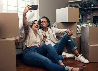Buy stock photo Shot of a young couple taking a selfie while busy moving into their new home