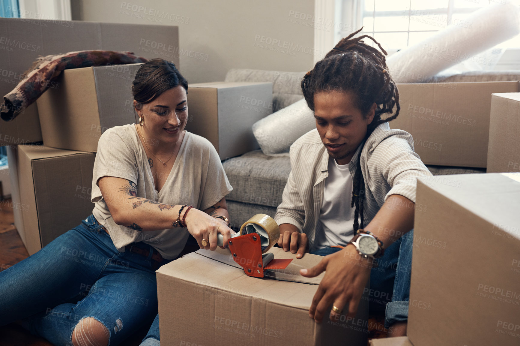Buy stock photo Cropped shot of a young couple taping up boxes at home