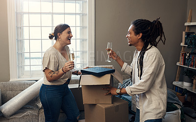 Buy stock photo Shot of a happy young couple having champagne to celebrate their new home