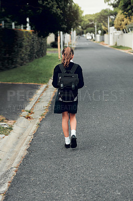 Buy stock photo Rearview shot of young schoolgirl walking to school