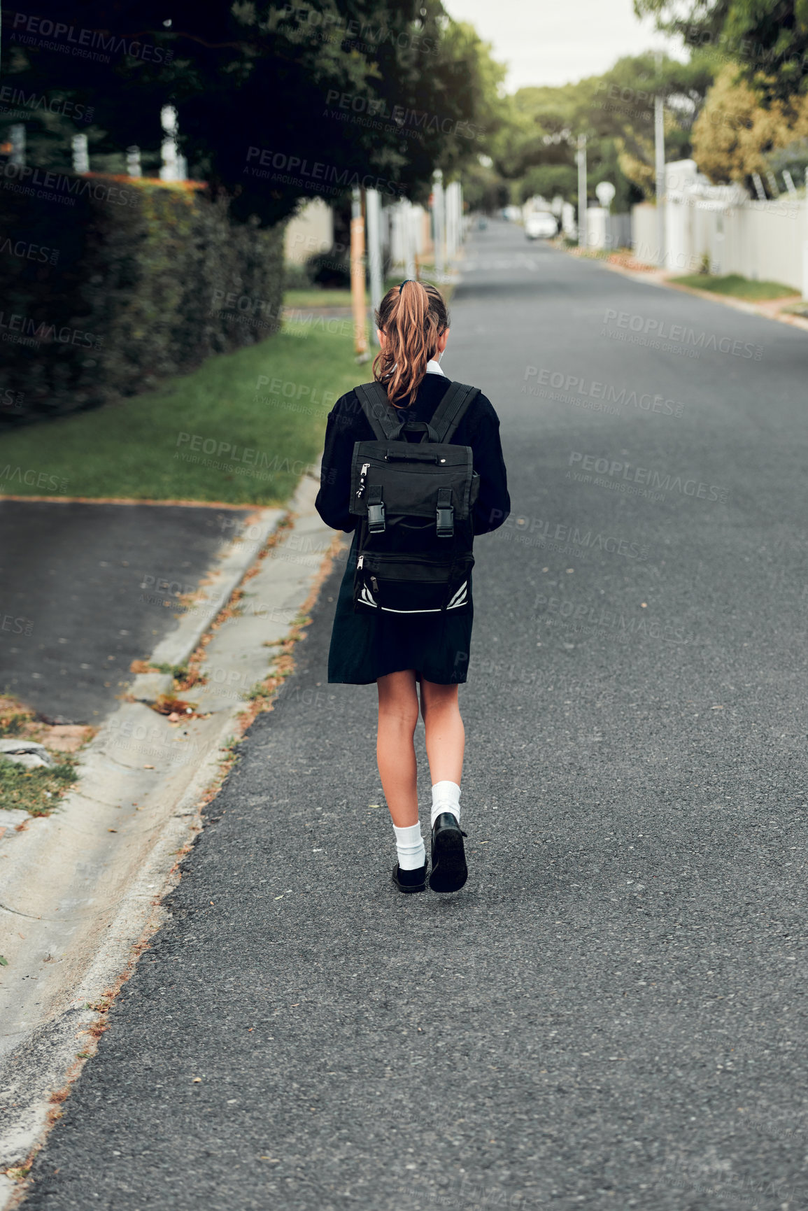 Buy stock photo Rearview shot of young schoolgirl walking to school