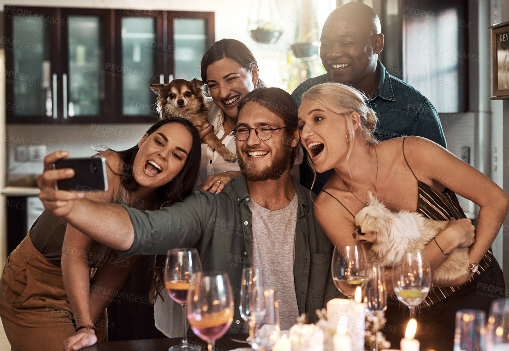 Buy stock photo Cropped shot of a group of cheerful young friends taking a self portrait together with a cellphone during christmas time