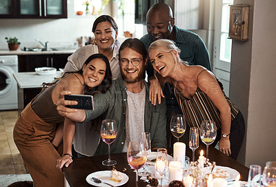 Buy stock photo Cropped shot of a group of cheerful young friends taking a self portrait together with a cellphone during christmas time