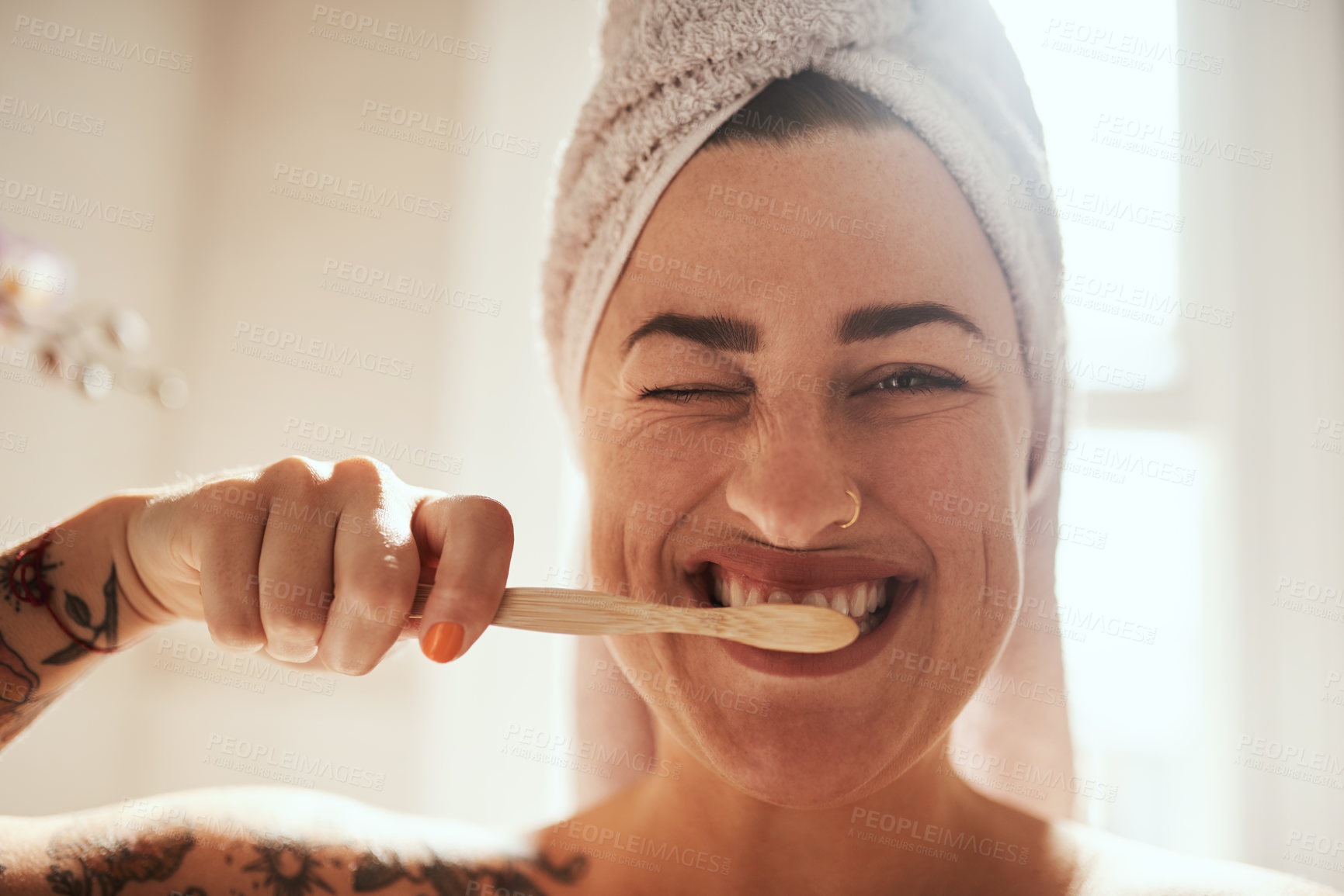 Buy stock photo Shot of an attractive young woman brushing her teeth in the bathroom at home