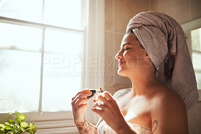 Buy stock photo Shot of a young woman spraying perfume during her morning beauty routine