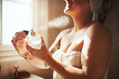Buy stock photo Cropped shot of a young woman spraying perfume during her morning beauty routine