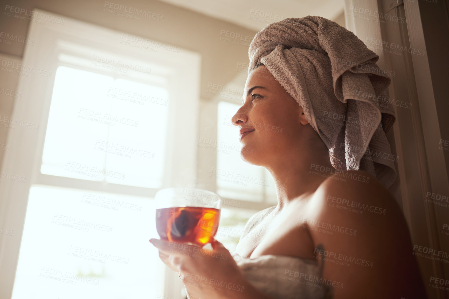 Buy stock photo Happy woman, relax and window with tea for morning routine, hygiene or cleanse in bathroom at home spa. Young, female person or vision with smile or beverage in wonder, thinking or dreaming for day