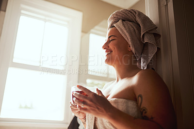 Buy stock photo Shot of a young woman having tea while going through her morning beauty routine at home