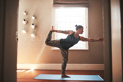 Buy stock photo Shot of a young woman practising yoga at home