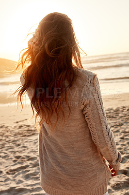 Buy stock photo Rearview shot of a young woman spending some time at the beach