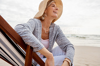 Buy stock photo Cropped shot of an attractive middle aged woman sitting on a lounger at the beach