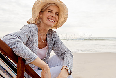 Buy stock photo Cropped shot of an attractive middle aged woman sitting on a lounger at the beach