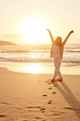 Buy stock photo Portrait of a young woman standing with her arms outstretched at the beach