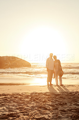 Buy stock photo Full length shot of an affectionate middle aged couple standing on the beach at sunset