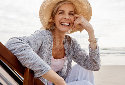 Buy stock photo Cropped portrait of an attractive middle aged woman sitting on a lounger at the beach