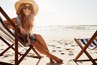 Buy stock photo Portrait of a young woman relaxing on a lounger at the beach