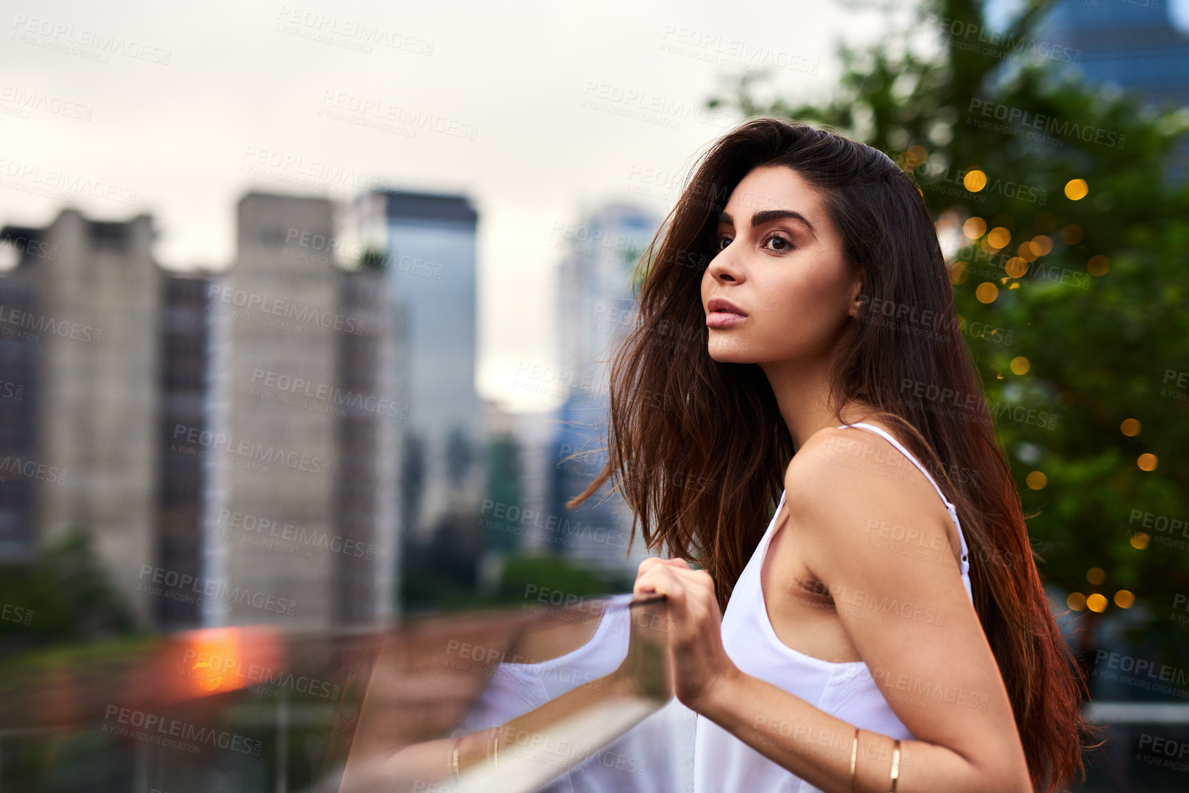Buy stock photo Cropped shot of an attractive young woman standing on a balcony outdoors during the day