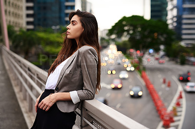 Buy stock photo Cropped shot of an attractive young woman leaning against a balcony in the city during the day