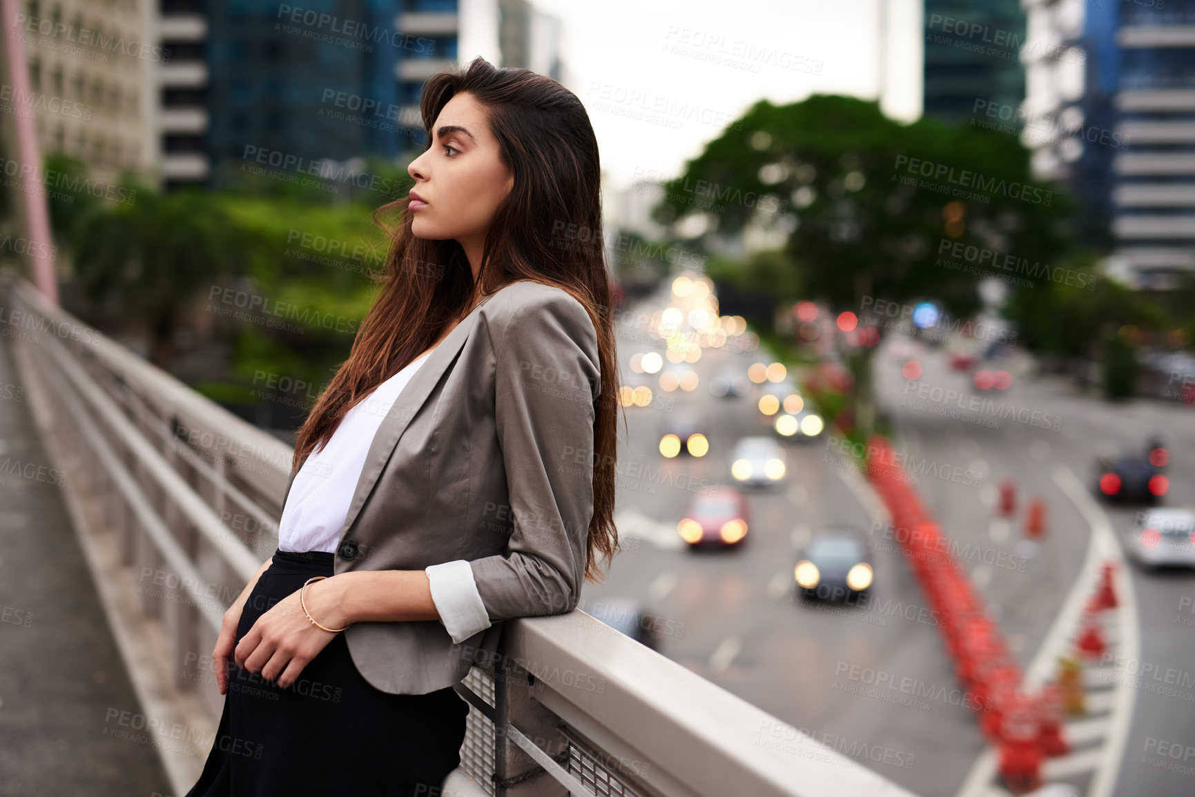 Buy stock photo Cropped shot of an attractive young woman leaning against a balcony in the city during the day