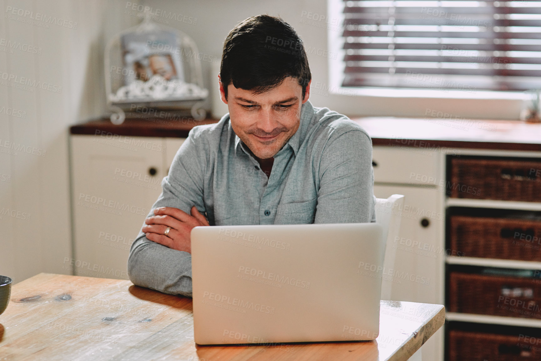 Buy stock photo Cropped shot of a man smiling while using his laptop