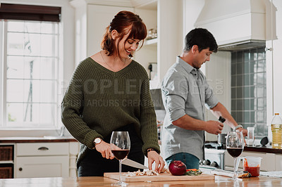 Buy stock photo Cropped shot of a couple cooking together in the kitchen at home