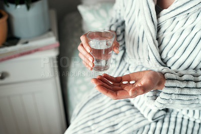 Buy stock photo Cropped shot of an unrecognizable woman taking her medication in her bedroom at home