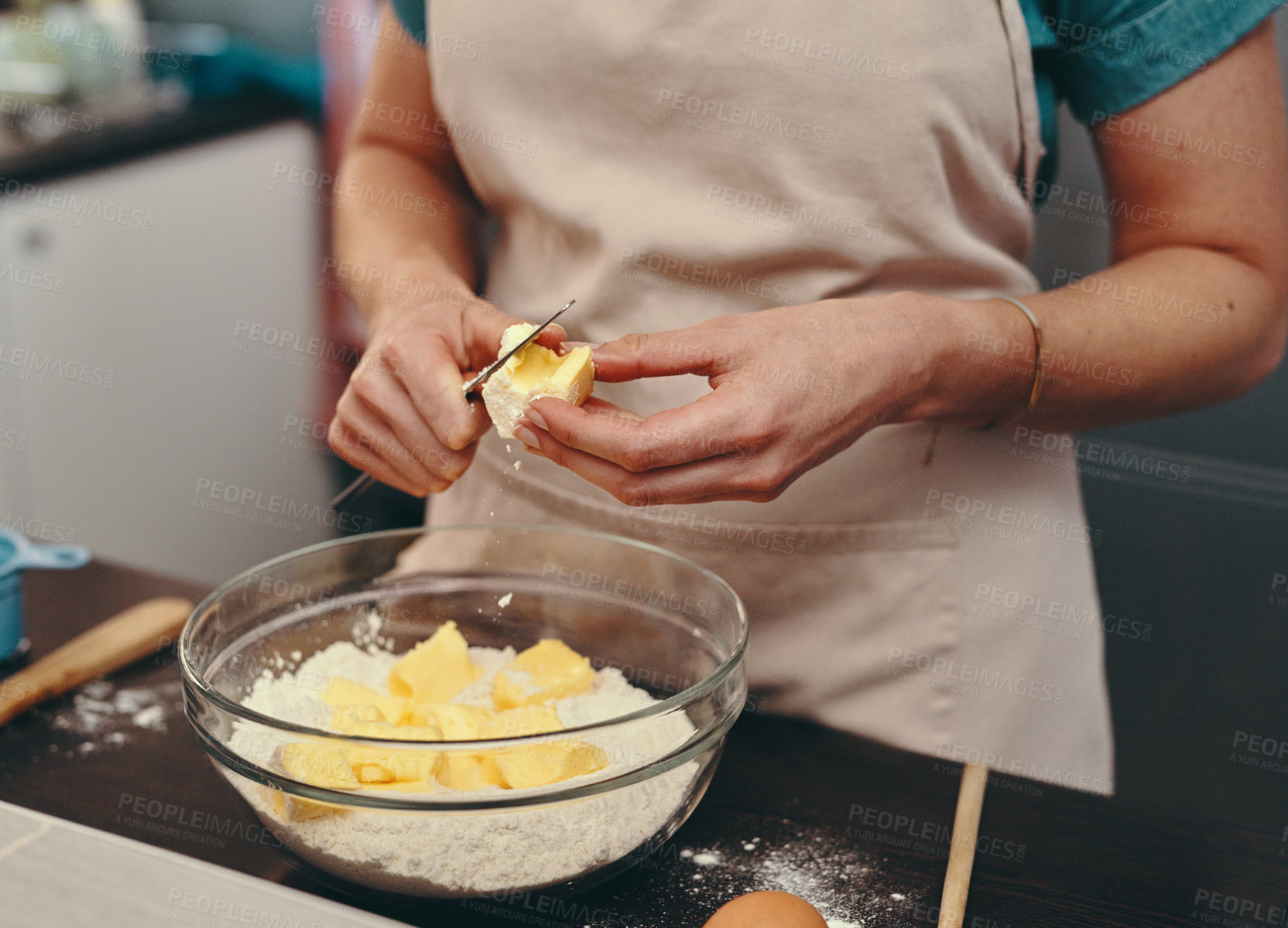 Buy stock photo Cropped shot of an unrecognizable woman cutting blocks of butter while baking inside her kitchen at home