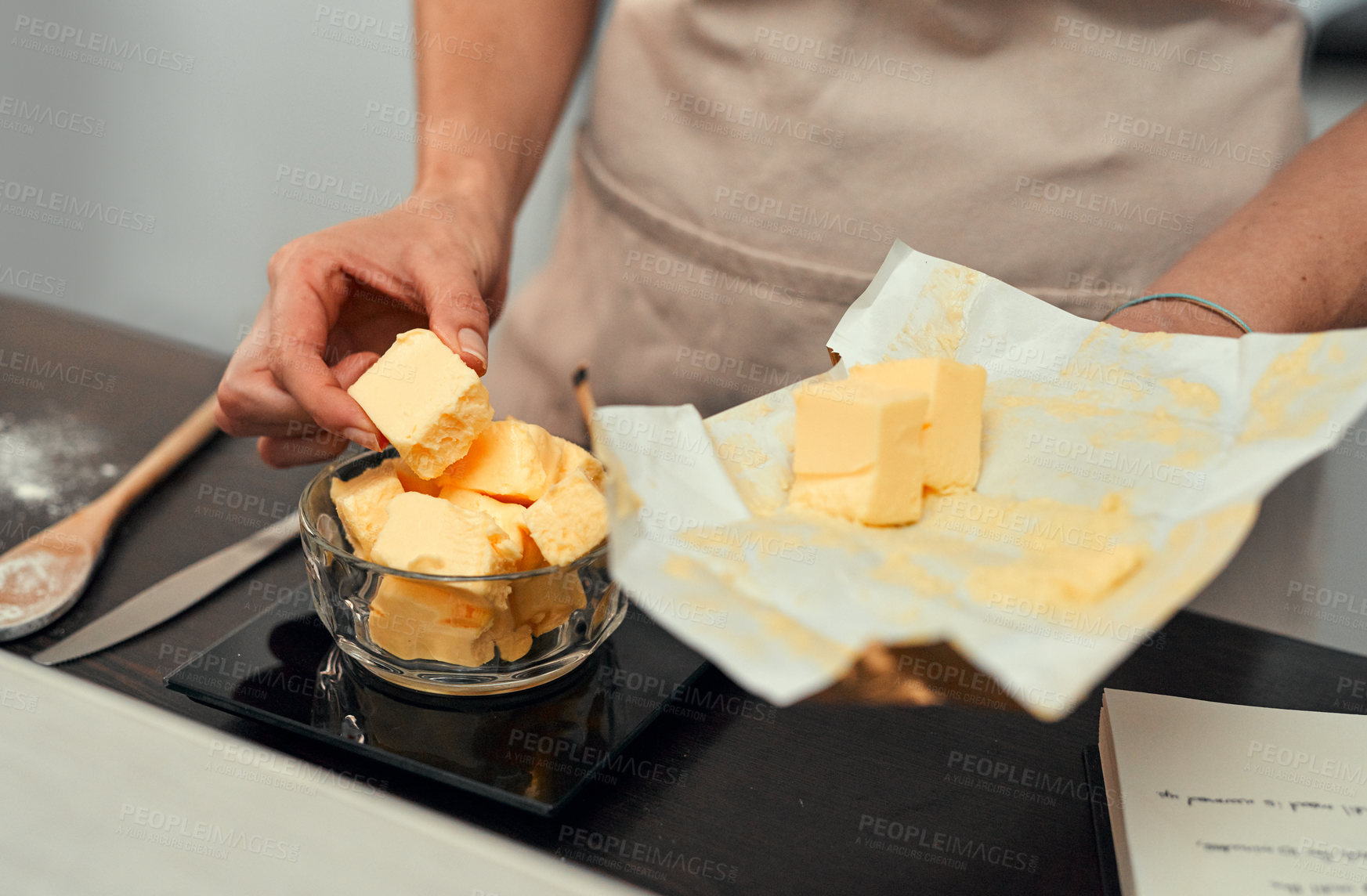 Buy stock photo Cropped shot of an unrecognizable woman adding blocks of butter inside a bowl while baking inside her kitchen at home